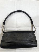 Front view of black leather Bueno purse with flap and strap