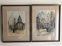 Both framed etchings side by side on wall
