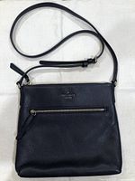 front view of purse showing overall design, strap, and front zip pocket