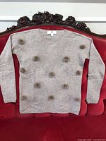 Front view of tan cashmere sweater with mink pom-poms