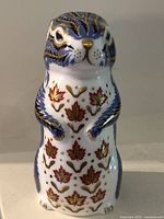 Front view of Royal Crown Derby chipmunk paperweight showing leaf decoration and gilding