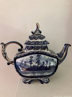 Full view of teapot showing handle, spout, lid and body decoration