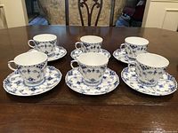 Full set of six cup and saucer pairs displayed on table