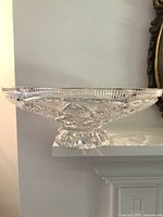 Side profile of clear cut crystal footed bowl on mantel