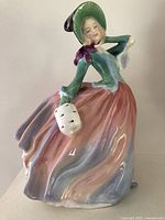 Front view of Royal Doulton Autumn Breezes figurine showing dress, bonnet, handbag