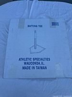 White cardboard box with product info and illustration of batting tee on front.