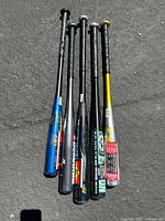 Five aluminum youth baseball bats from Easton and DeMarini with clear brand labeling and tape grips