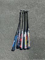 Top down view of 5 aluminum baseball bats showing their grips and logos.