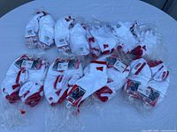 Group of bundled, packaged socks on a round table showing the red and white color scheme and packaging.