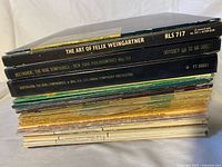 Stacked view of approximately 30 LPs showing spines with titles and catalog numbers