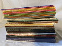 Side view of both stacks showing thickness and variety of albums and boxes; visible spines identify several titles and labels