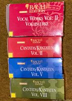 Four colored slipcase boxes labeled Bach Edition Vocal Works Vol. II and Cantatas Vol. II, V, VIII