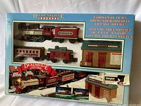 Front of boxed New Bright Dickensville Express train set showing locomotive, passenger coach, depot building on packaging