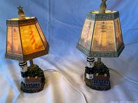 Both lighthouse lamps lit showing shades and bases