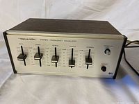 Front view showing Realistic stereo frequency equalizer with five sliders and power switch