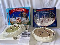 Both skating pond sets with boxes, manuals and figurines visible