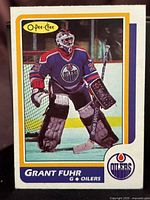 Front of 1986-87 O-Pee-Chee Grant Fuhr hockey card showing player in goalie gear with Edmonton Oilers jersey.