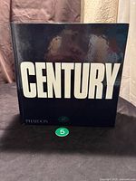 Front cover of the hardcover book showing the title 'CENTURY' in large white block letters on a black background, the Phaidon Press logo is visible.