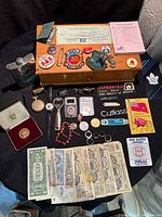 Wooden box with assorted patches, coins, rings, banknotes, watches, cufflinks, flask, pins and other small items