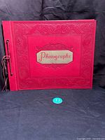 Front view of the large vintage burgundy Premier photo album with an embossed cover and 'Photographs' label.