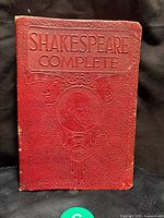 Front cover of vintage 1926 Shakespeare complete works book showing red embossed cover with Shakespeare portrait.