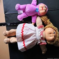 Both dolls side by side next to ruler showing scale