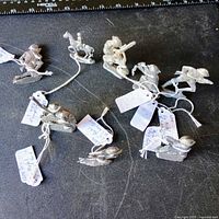 Group of eight unpainted lead toy soldiers with tags