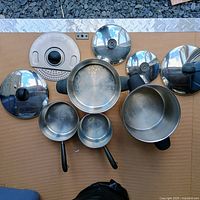 All cookware pieces laid out showing pots, lids and strainer insert