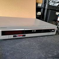 Front angled view of silver Sony DVD player showing tray, display, control buttons