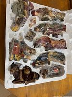 Nine figurines in original Styrofoam tray, each wrapped in plastic