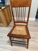 Front view of oak side chair showing overall structure and cane seat