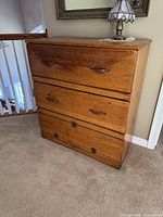 Front view of restored wooden cabinet with closed drawers and drop-front compartment
