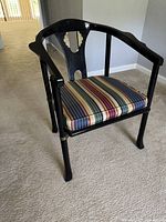 Front view of black hardwood armchair with striped cushion