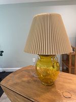 Lamp with shade on wooden surface