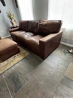 Front view of brown leather sofa and ottoman