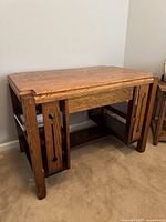 Front angled view of oak mission style desk showing drawer and shelves