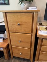 Front view of closed three-drawer oak filing cabinet
