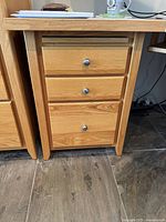 Front view of oak pedestal showing closed drawers