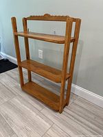 Front angled view of solid oak three-shelf wall unit