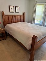 Full view of assembled cherry queen bed frame in room