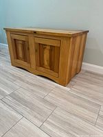Front and side view of poplar TV credenza showing two paneled doors and arched base