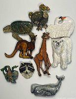 Full lot of ten animal brooches arranged on white background
