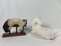 Full view of the resin cat on wooden ledge and ceramic unicorn figurine