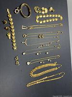 Full lot spread showing multiple bracelets, earrings, and necklaces arranged on black background.