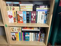 DVD collection on two wooden shelves showing assorted complete TV series and collections including I Love Lucy, Three's Company, Soap, Gilligan's Island, Esther Williams, Elvis Presley, and more.