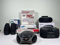 Wide view of all items arranged on table, showing boxes and individual devices.