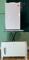 Igloo mini fridge on a raised stand with Clairon ConVector 1500 heater on the floor in front