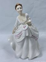 Front view of the Royal Doulton Carol figurine showing seated woman holding an embroidery hoop with floral stitching.