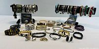 Full display of various bracelets and rings laid out with two bracelet stands holding bangles and cuff bracelets.