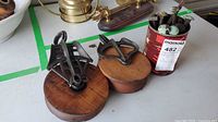 Two pulleys and can of bolts/spikes displayed on table